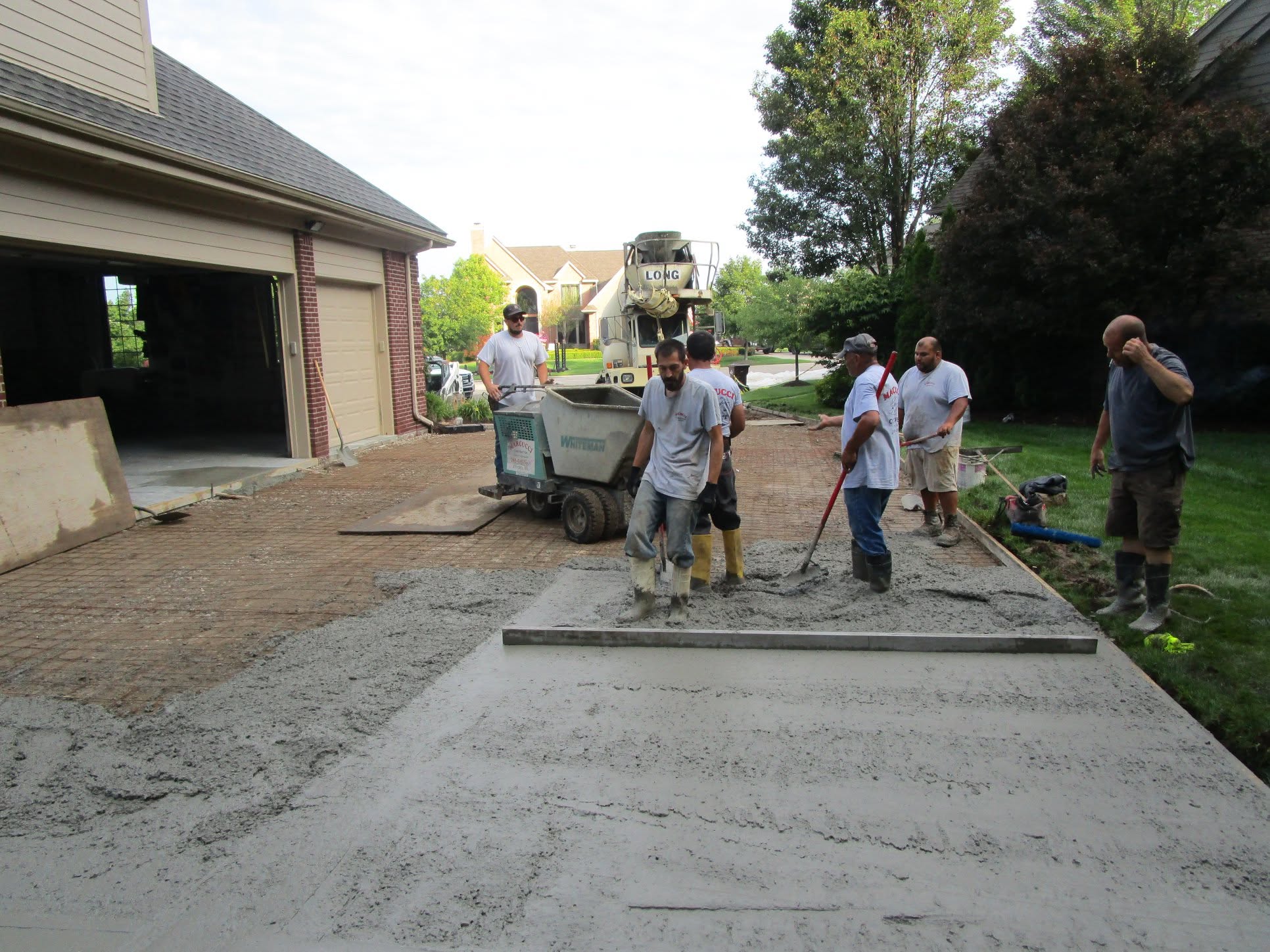 Marcucci Concrete Construction crew placing a reinforced concrete driveway over wire mesh in Oakland County, Michigan