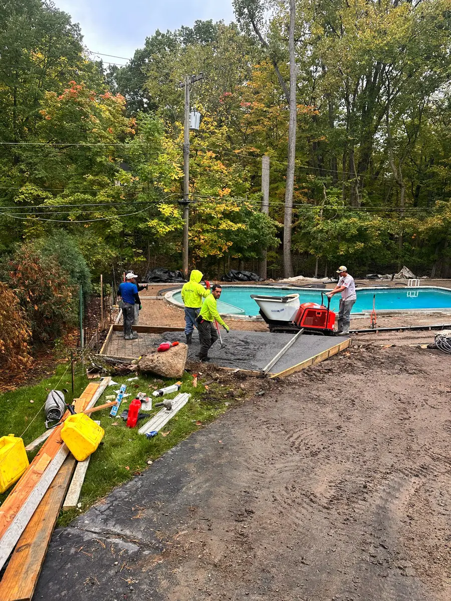 Marcucci Concrete crew placing a new concrete pool deck with a tracked power buggy and screed in Oakland County, Michigan