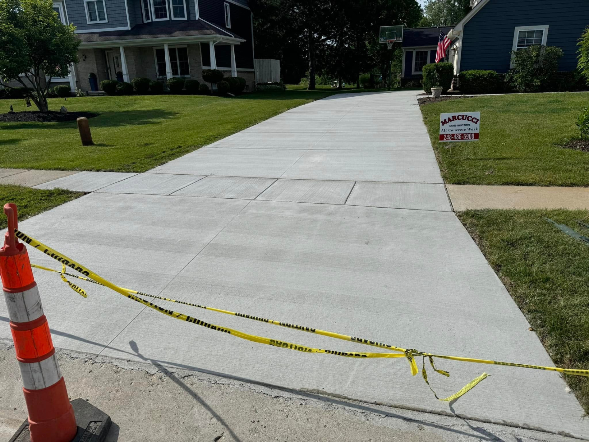 New broom-finish concrete driveway with apron and sidewalk by Marcucci Concrete Construction in Oakland County, Michigan