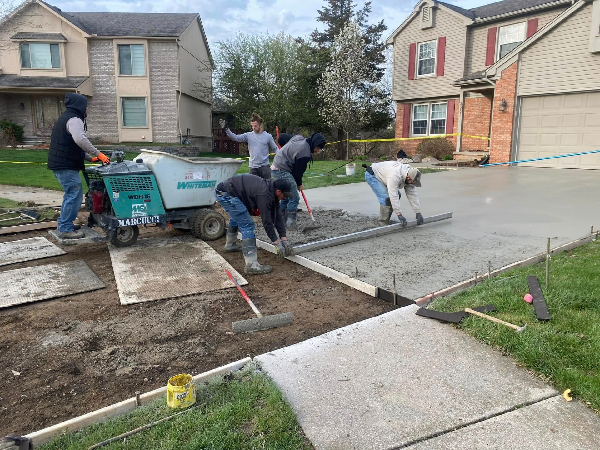 Marcucci Concrete Construction crew placing and screeding a new residential concrete driveway in Oakland County, Michigan