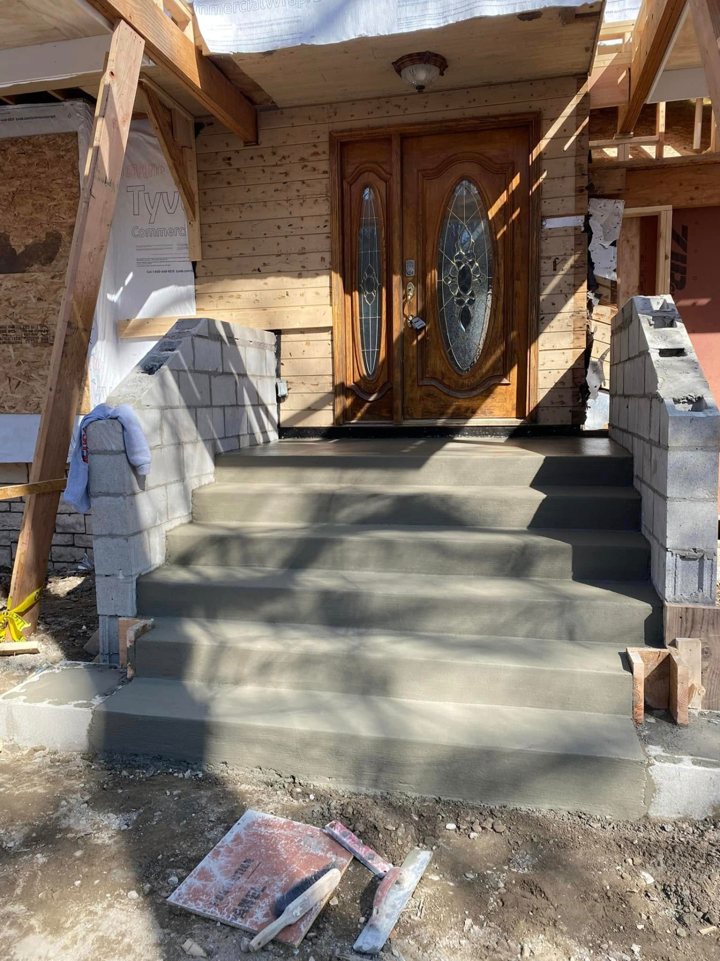 New concrete front steps and porch landing finished by Marcucci Concrete Construction in Oakland County, Michigan