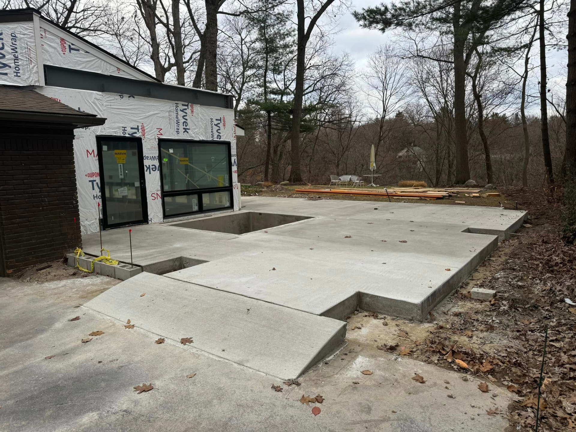 Poured concrete patio slab with step and ramp at a home addition by Marcucci Concrete Construction in Oakland County, Michigan