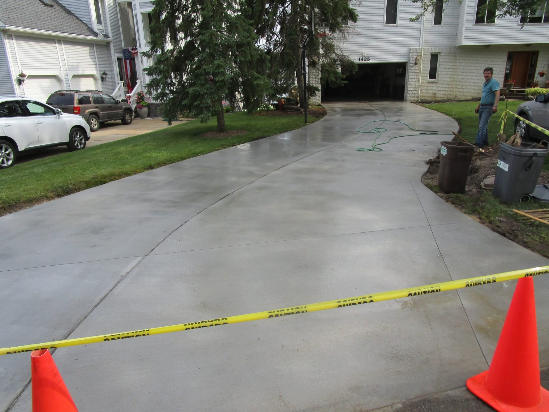 Curved broom-finish concrete driveway replacement with control joints by Marcucci Concrete Construction in Oakland County, Michigan