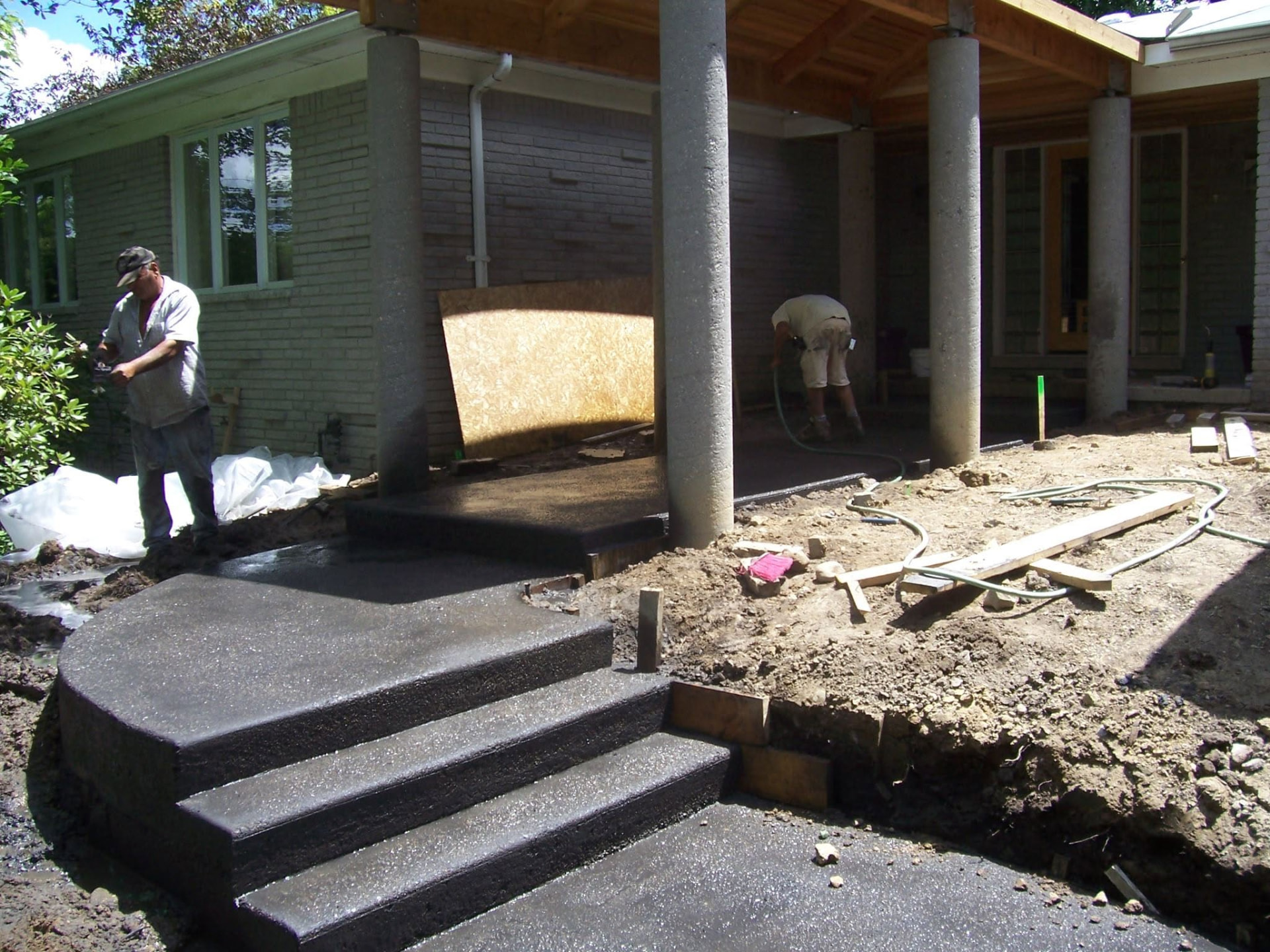 Finished rounded concrete entry steps, round porch pillars and covered walkway by Marcucci Concrete Construction in Oakland County, Michigan