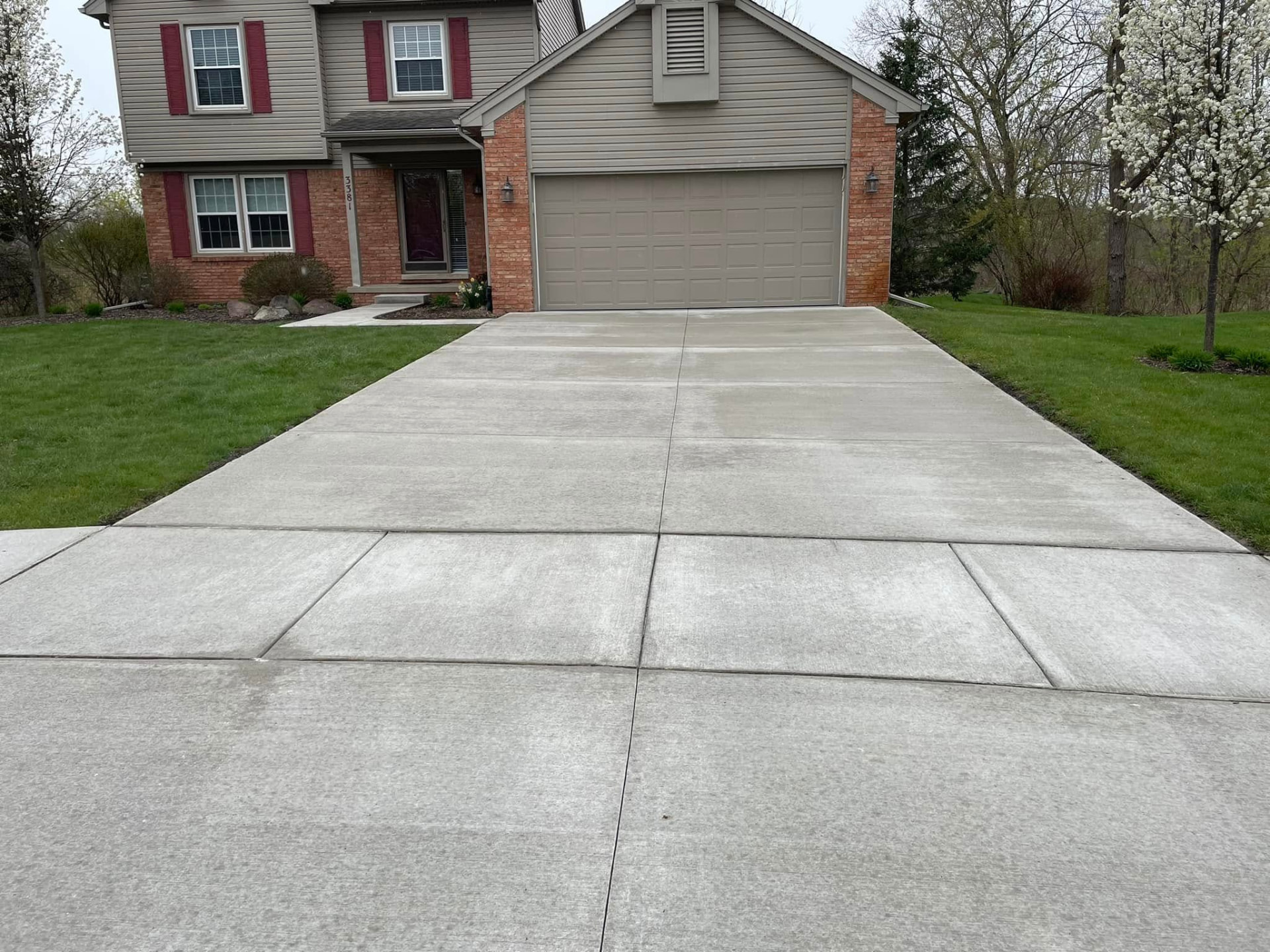 Finished broom-finish concrete driveway replacement with garage apron by Marcucci Concrete Construction in Oakland County, Michigan