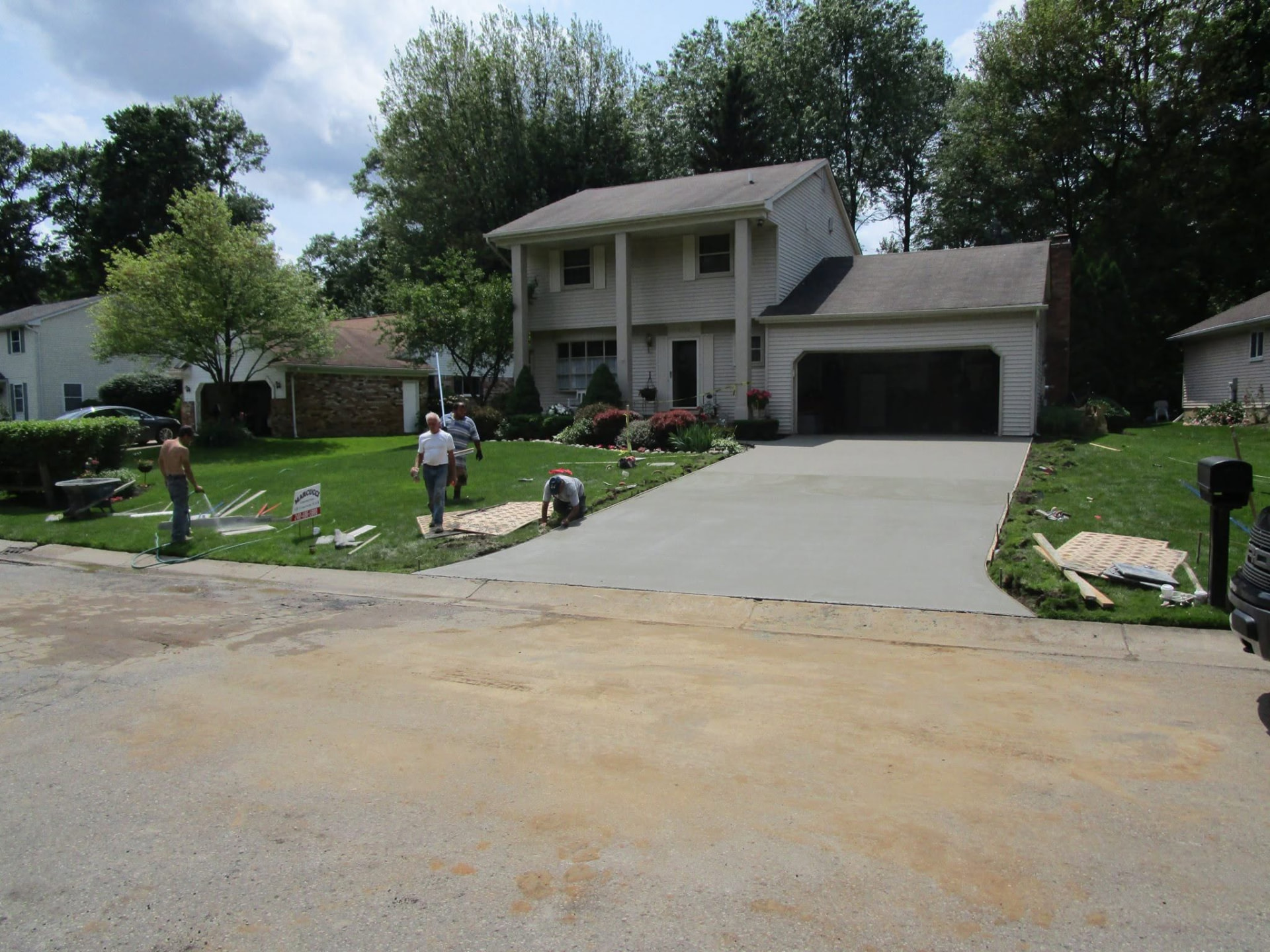Marcucci Concrete Construction crew finishing a new concrete driveway at a colonial home in Oakland County, Michigan