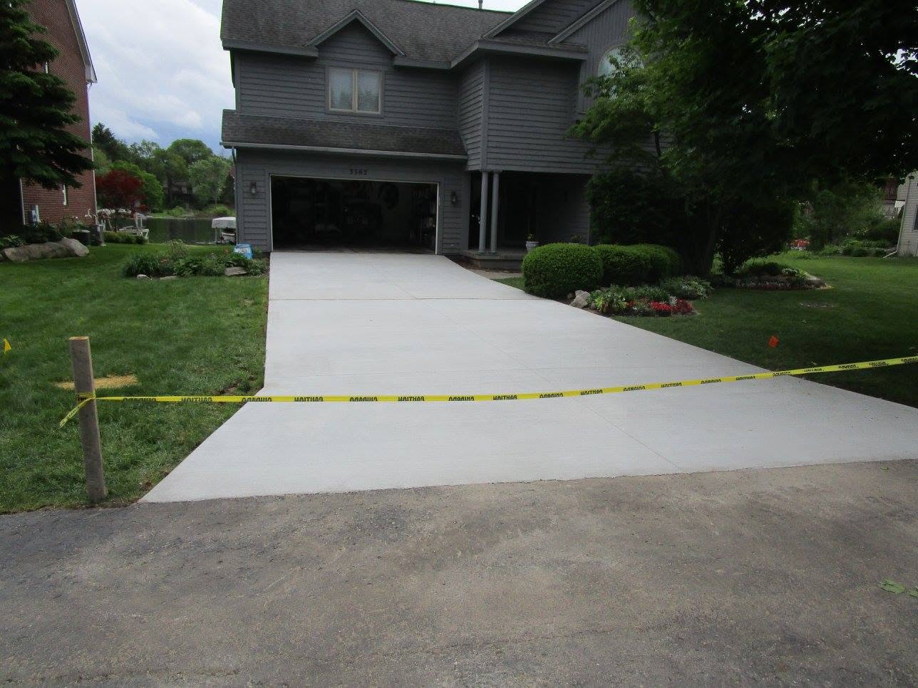 Finished broom-finish driveway and approach leading to an attached two-car garage. Marcucci Concrete Construction in Oakland County, Michigan.