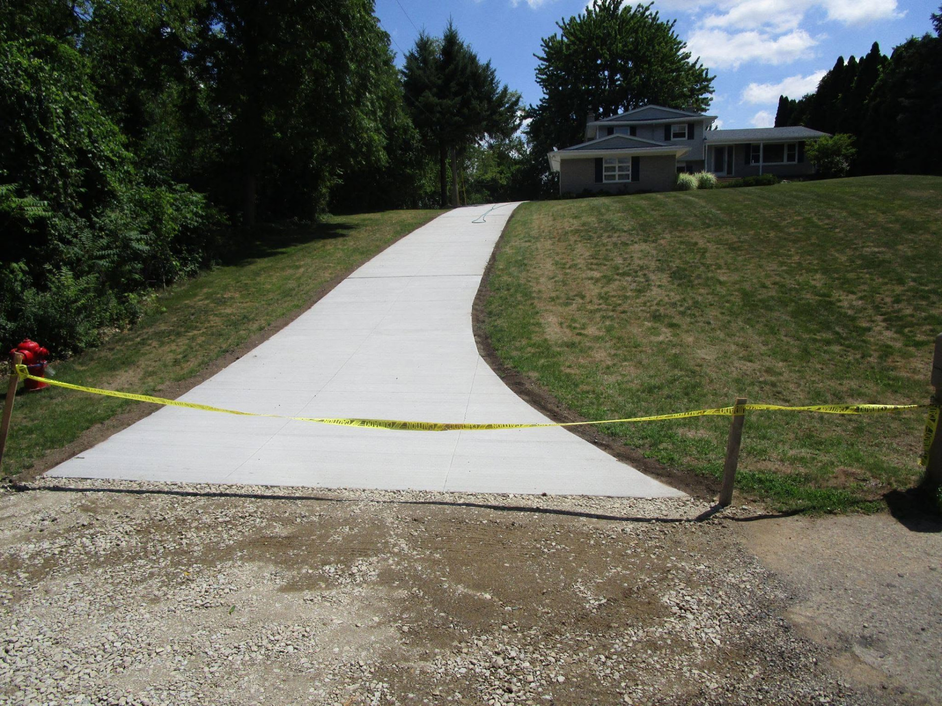 Long sloped concrete driveway on a hillside lot installed by Marcucci Concrete Construction in Oakland County, Michigan