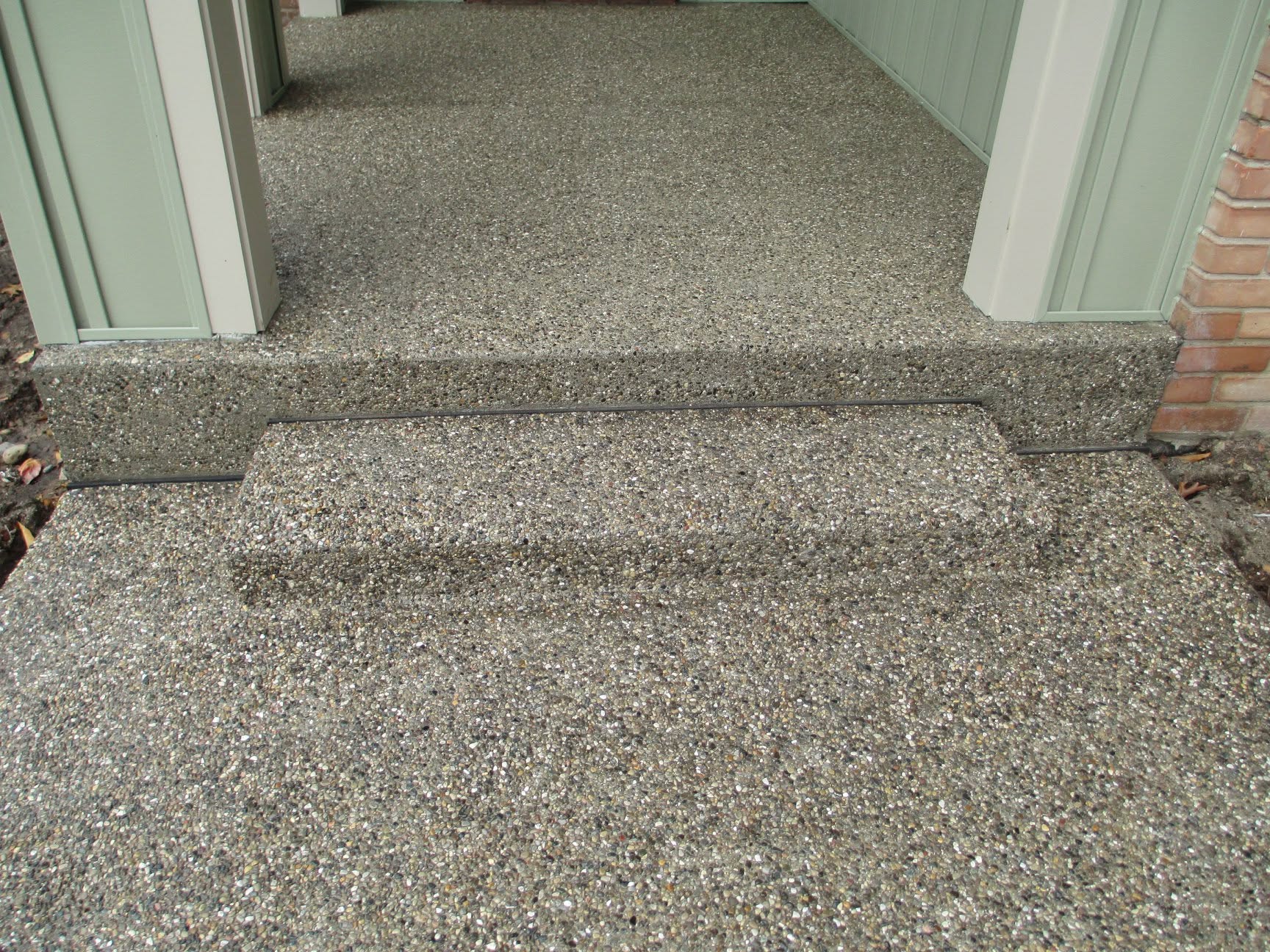 Exposed aggregate concrete walkway landing and steps by Marcucci Concrete Construction in Oakland County, Michigan
