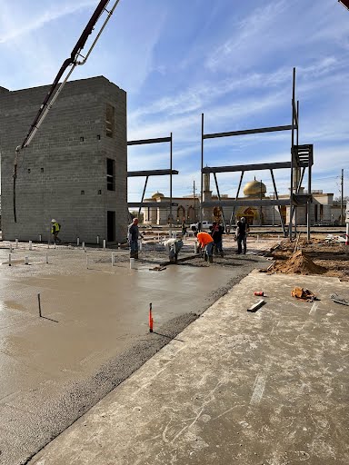 Marcucci concrete crew placing and screeding a commercial building slab with a boom pump in Michigan