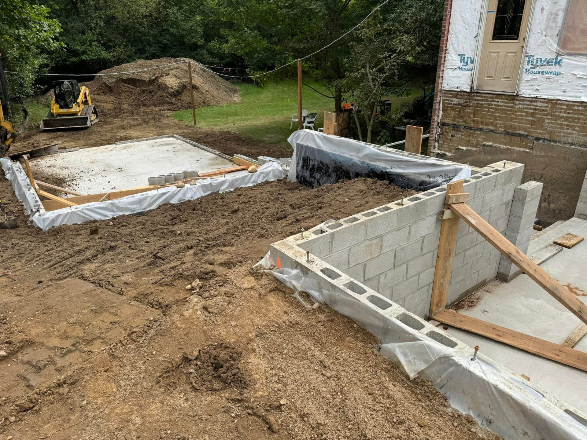 Concrete block foundation construction and surrounding excavation at a residential addition site. Marcucci Concrete Construction in Oakland County, Michigan.
