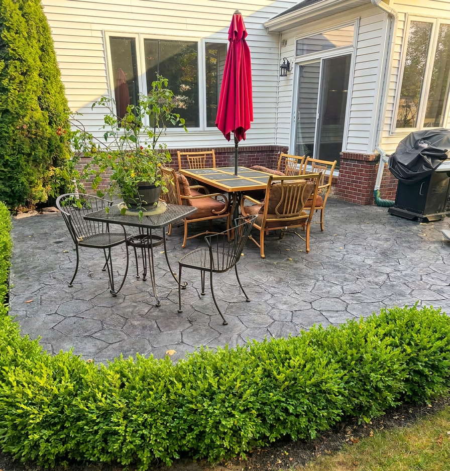 Gray stone-pattern stamped concrete backyard dining patio by Marcucci Concrete Construction in Oakland County, Michigan