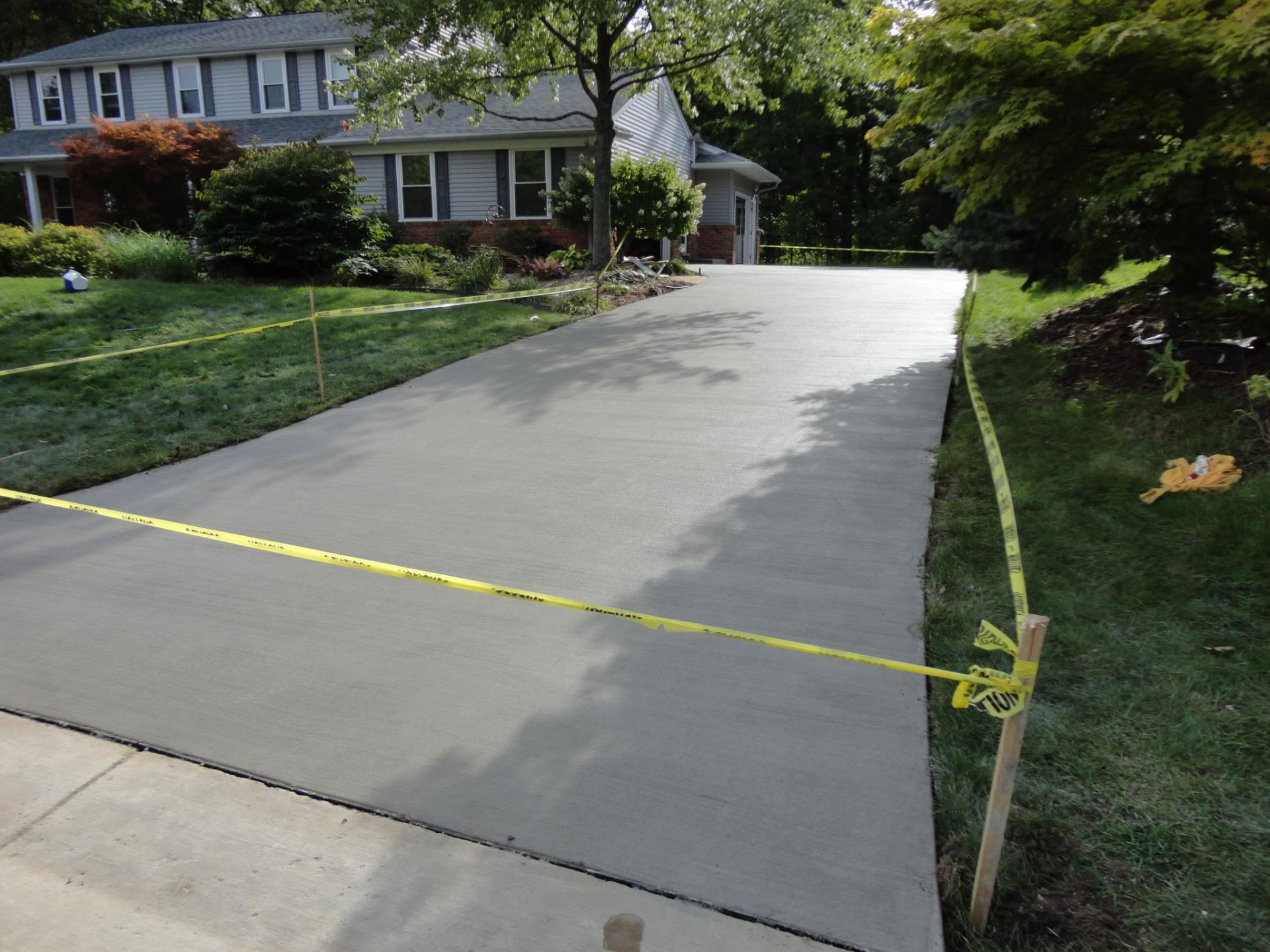 Freshly poured broom-finish concrete driveway replacement by Marcucci Concrete Construction in Northville, Michigan