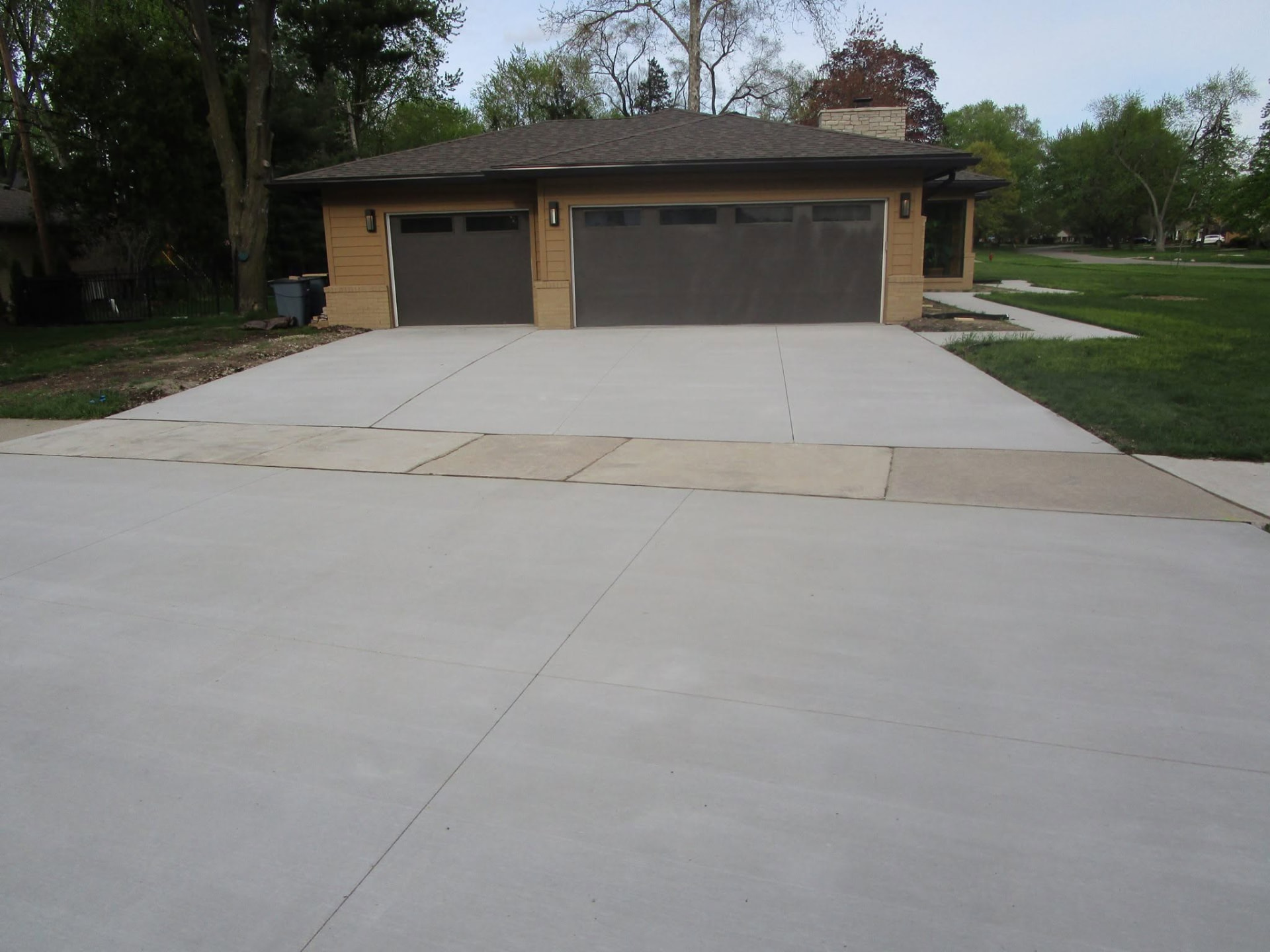 Extra-wide broom-finish concrete driveway for a three-car garage by Marcucci Concrete Construction in Oakland County, Michigan