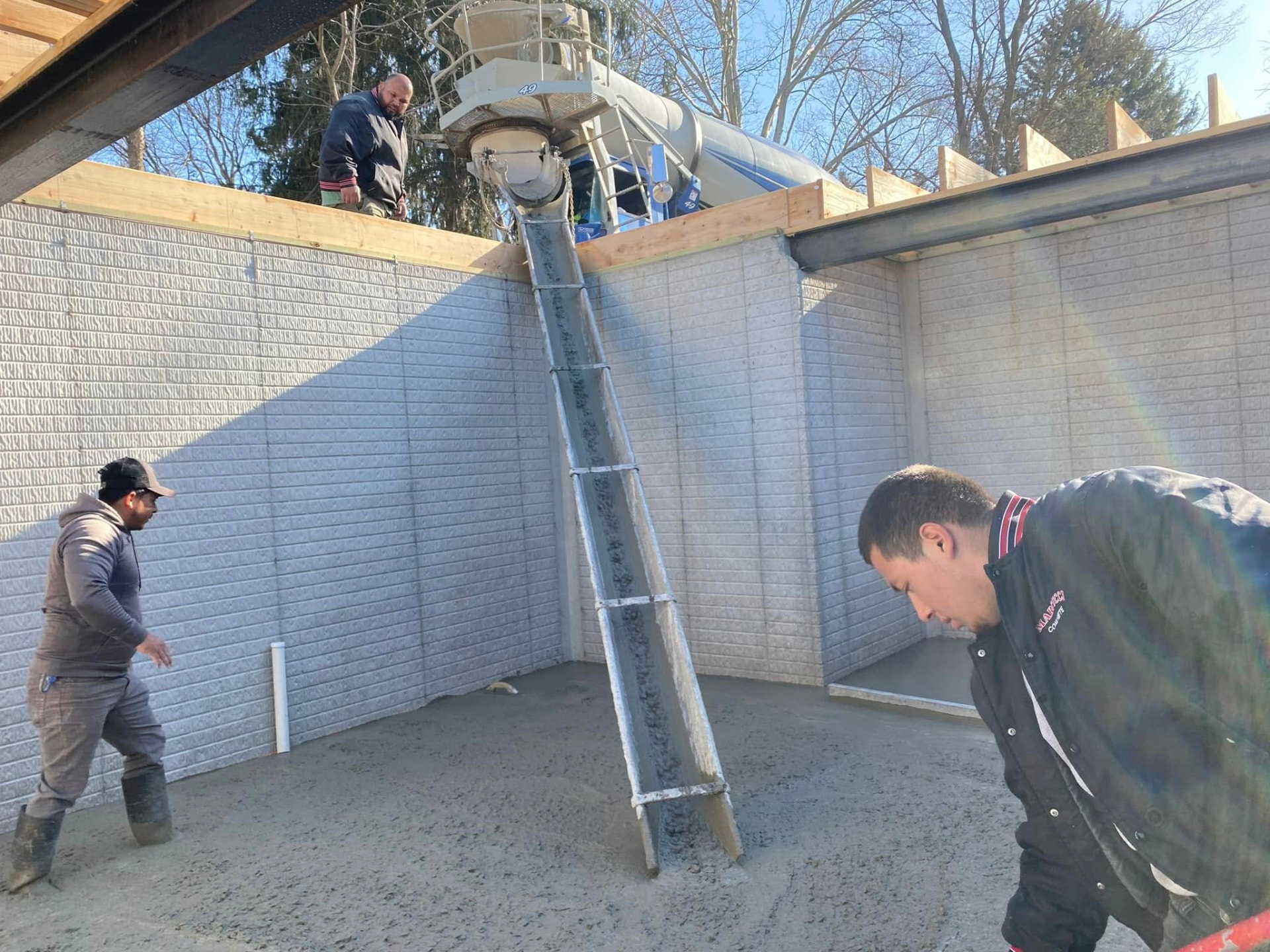 Marcucci Concrete Construction crew placing a residential basement foundation floor in Oakland County, Michigan