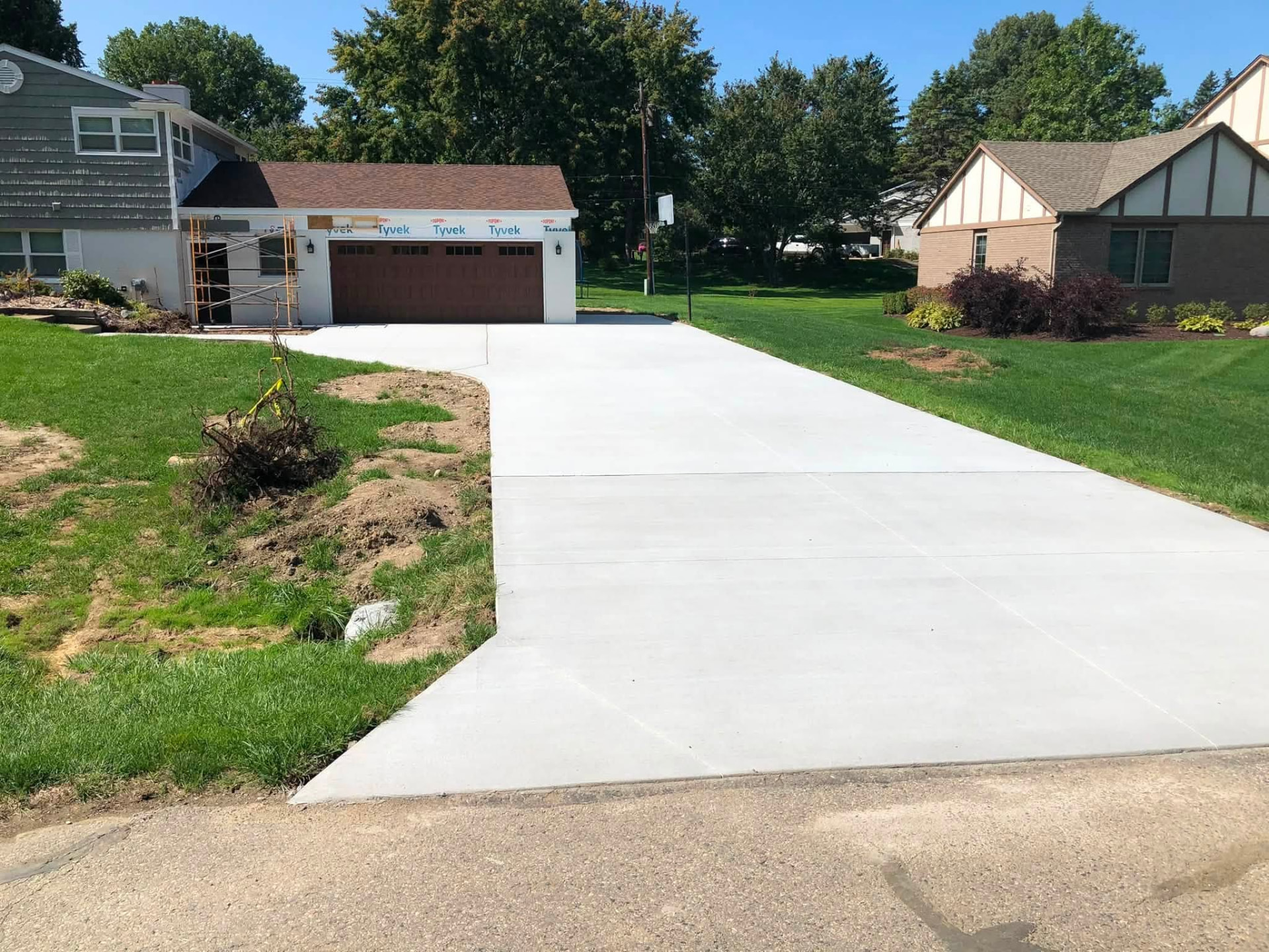 Long new broom-finish residential concrete driveway with control joints in Oakland County, Michigan