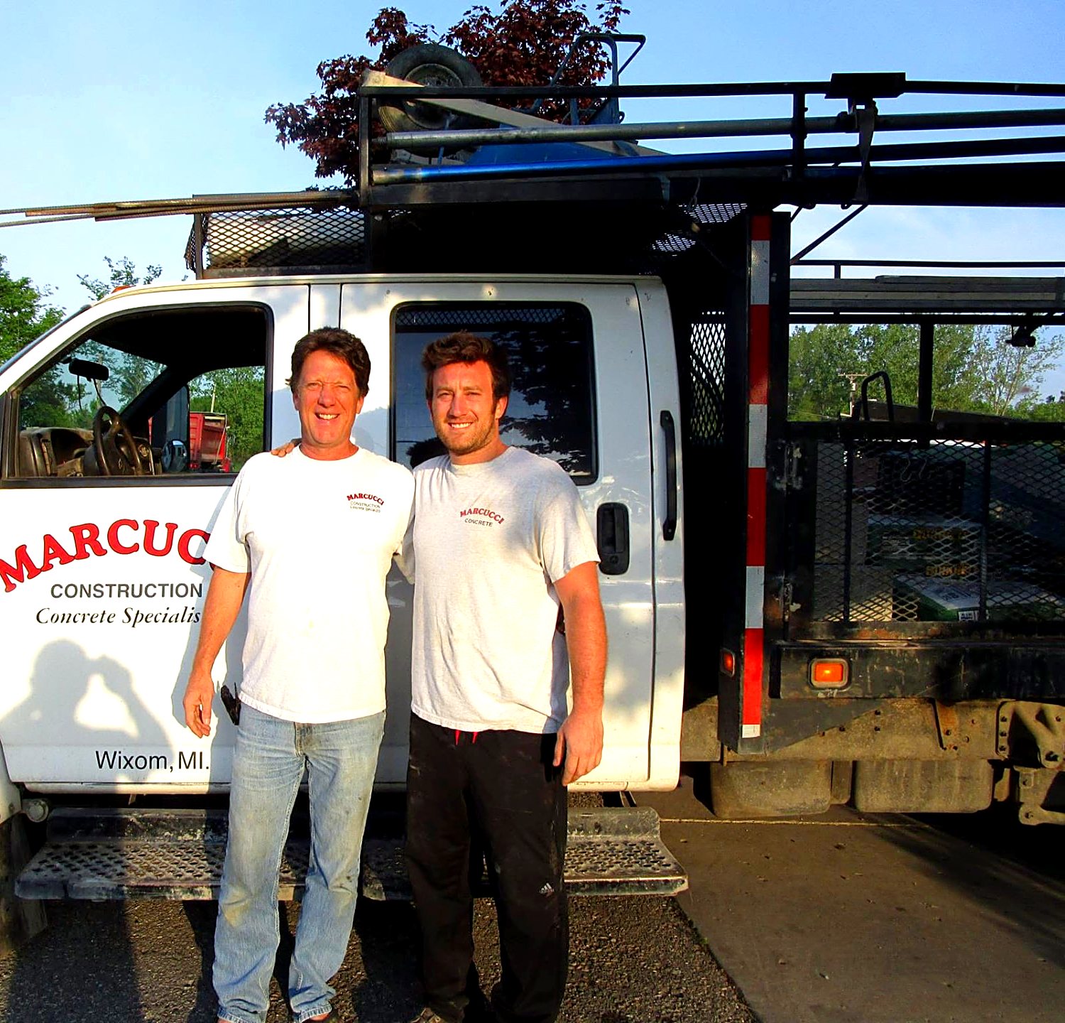 Tom Marcucci and his son Tony Marcucci standing in front of a Marcucci Construction concrete truck in Wixom, Michigan