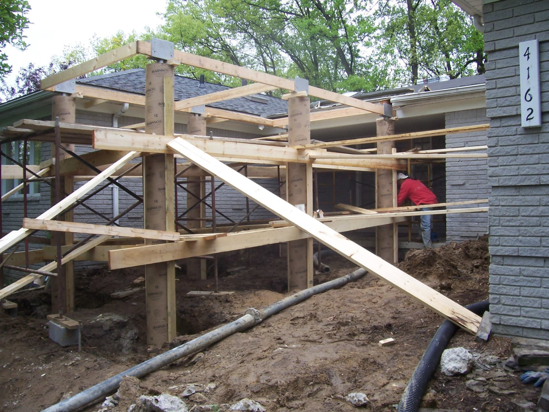Round fiber-form pillar footings and framing for a covered entry porch built by Marcucci Concrete Construction in Oakland County, Michigan