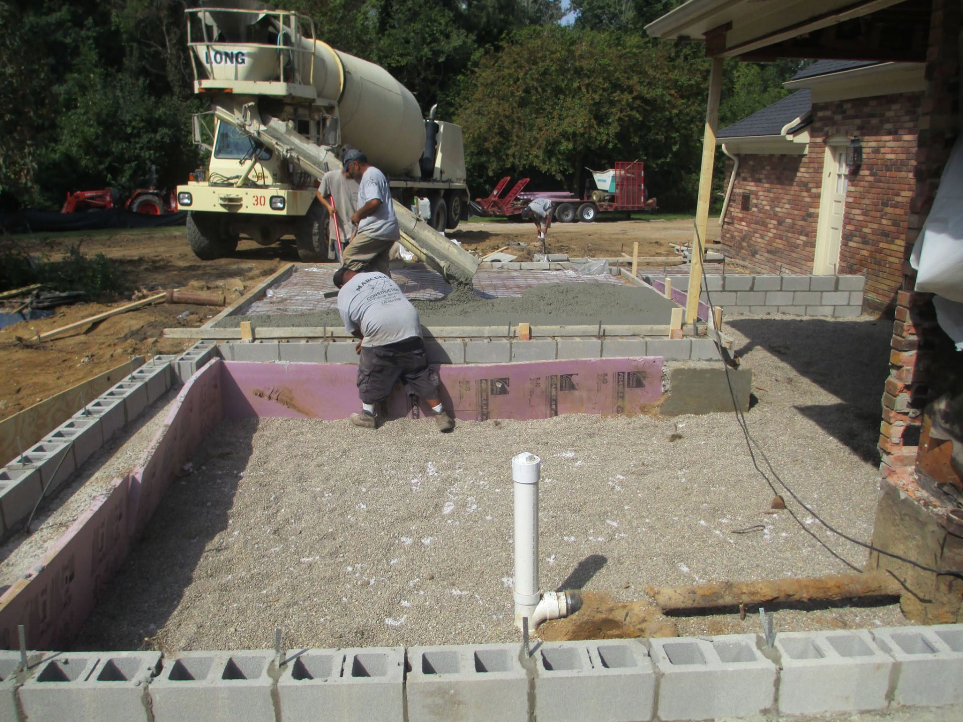 Marcucci Concrete Construction crew pouring a slab over an insulated block foundation for a home addition in Oakland County, Michigan