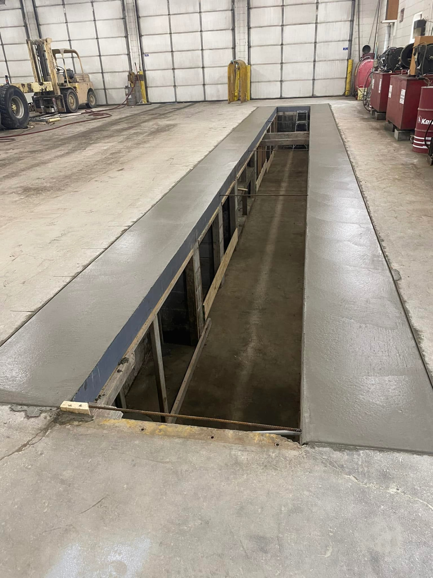 New concrete perimeter around a commercial mechanic shop vehicle service pit by Marcucci Concrete Construction in Oakland County, Michigan