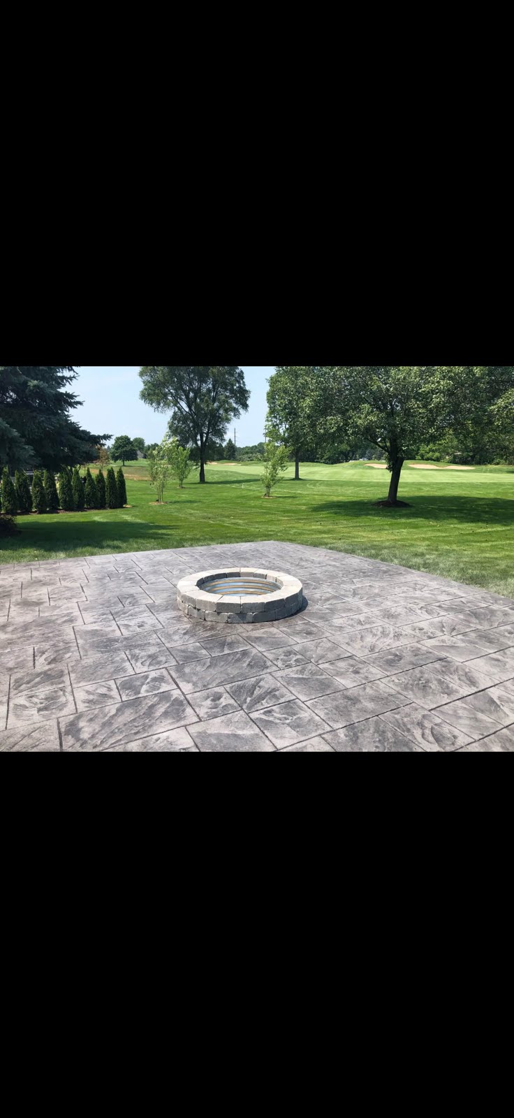 Stamped concrete patio with built-in fire pit installed by Marcucci Concrete Construction in Highland, Michigan
