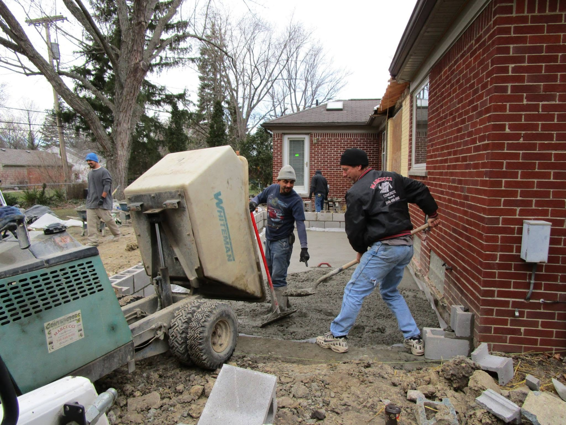 Marcucci Concrete Construction crew placing concrete for a patio addition slab in Oakland County, Michigan