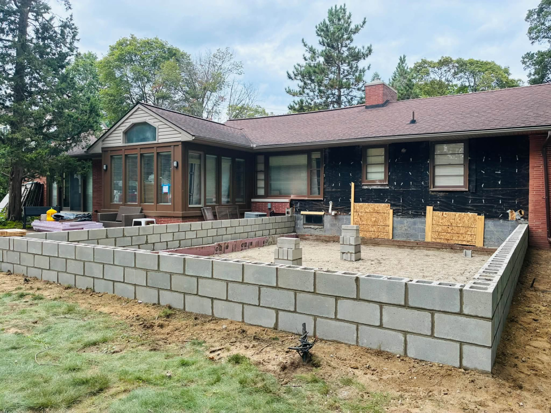 Residential block foundation and compacted base prepared for a patio addition in Oakland County, Michigan